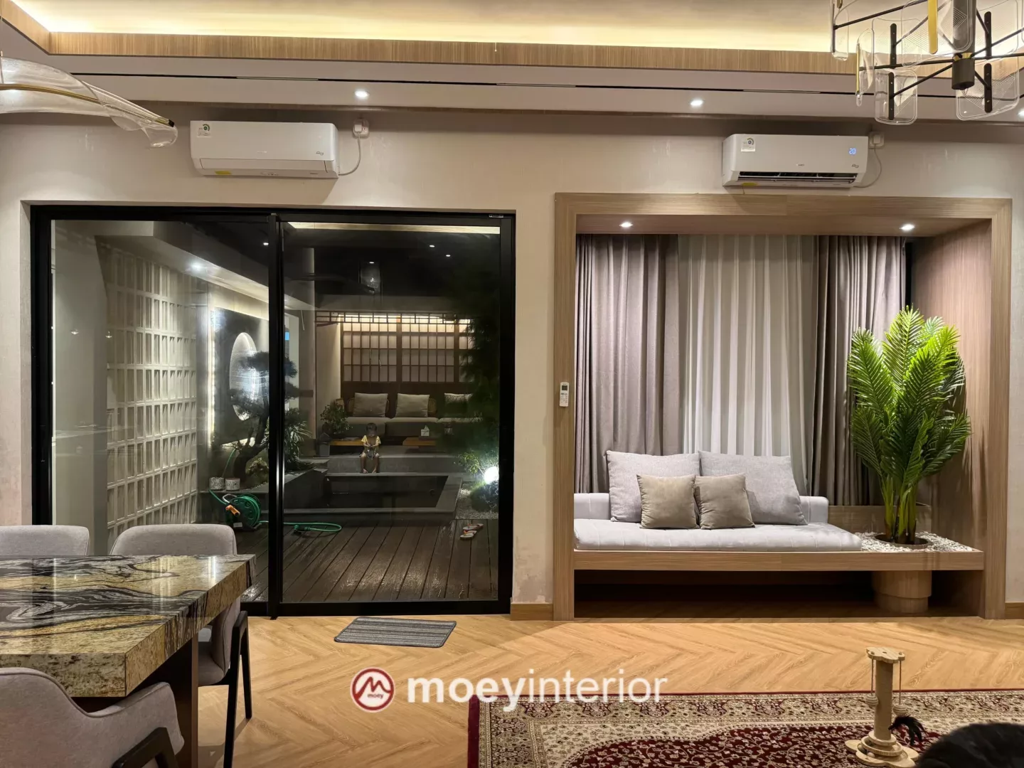 Ruang tamu dengan built-in daybed dan sliding door ke taman